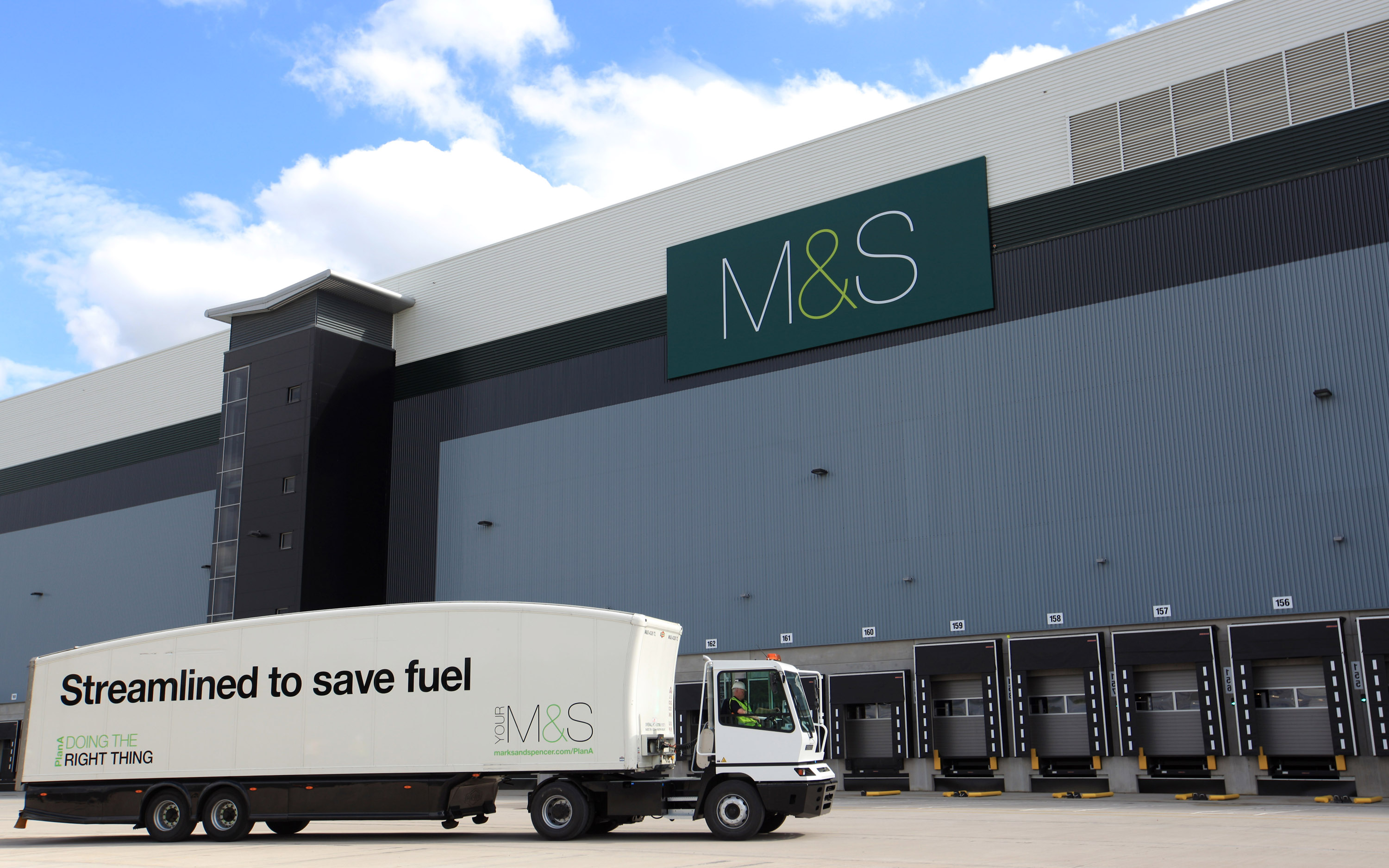 A truck infront of a large warehouse