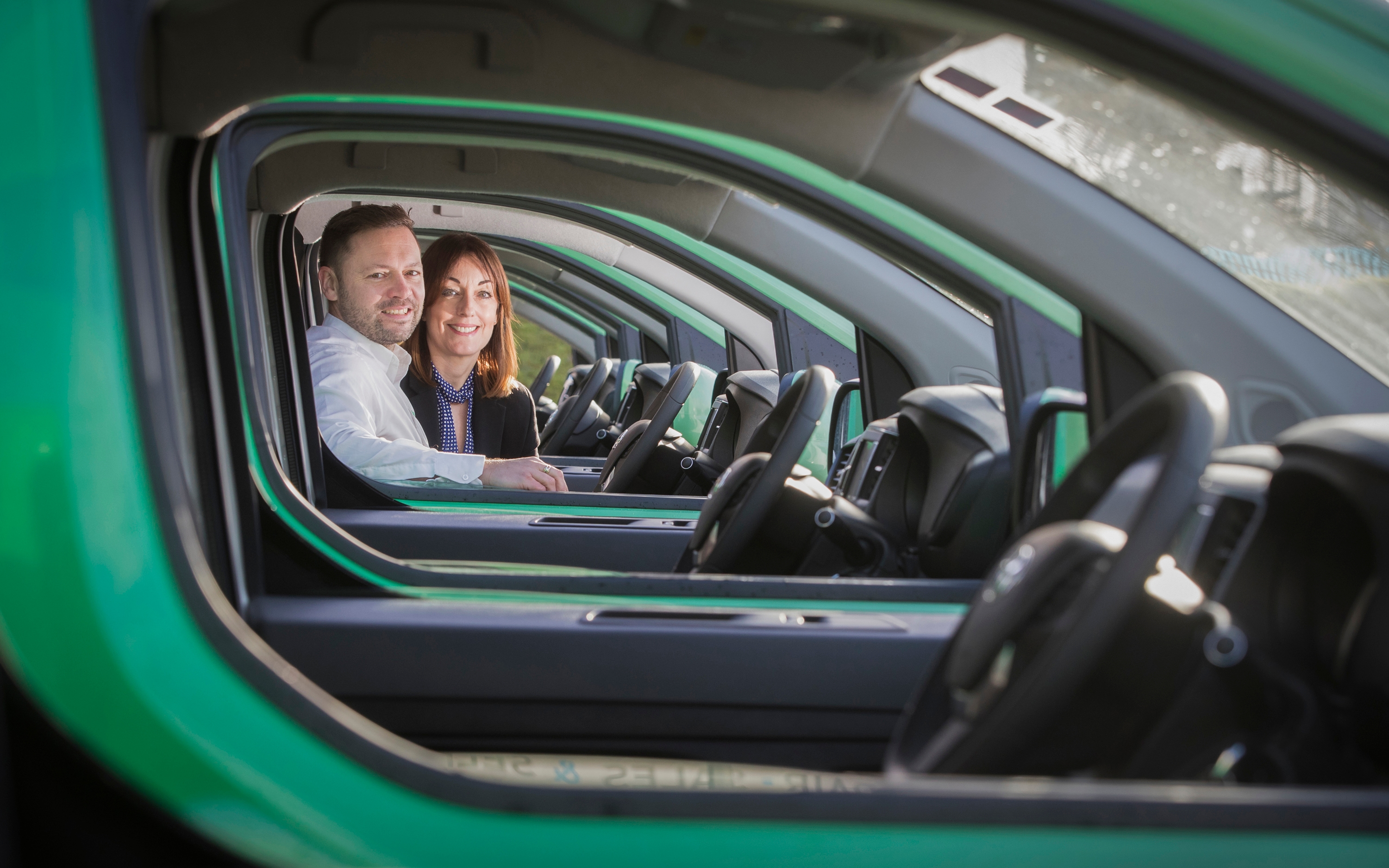 Two people smiling in a car